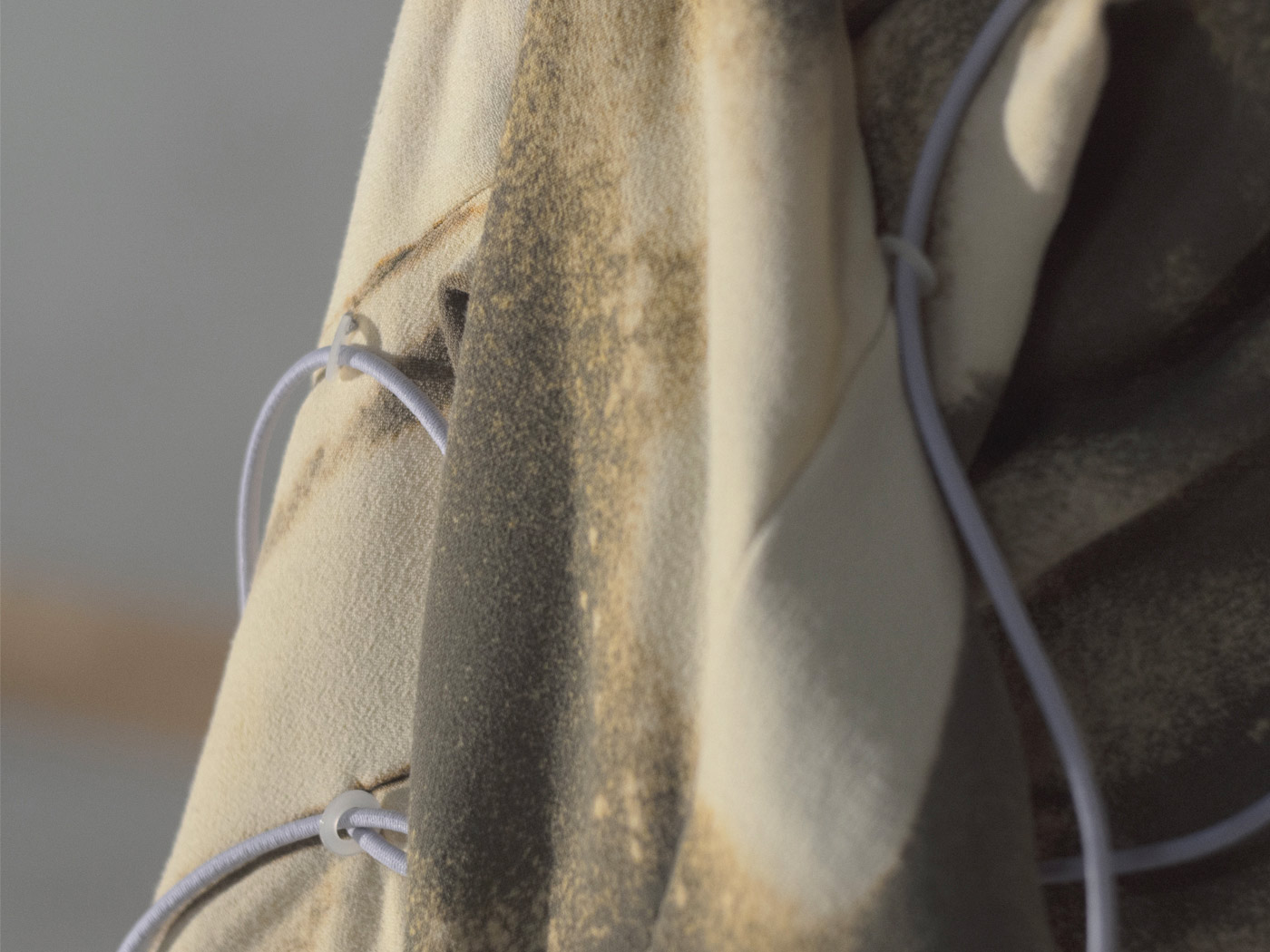 Close-up of the torso hanging from the pedestal. Transparent rings can be seen at the seams, through which the purple-colored cables that start at the neck guard run.