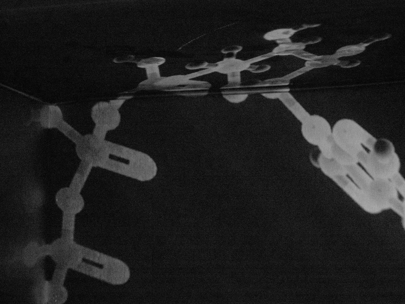 A molecular structure of adenosine triphosphate, projected into the corner of a room.